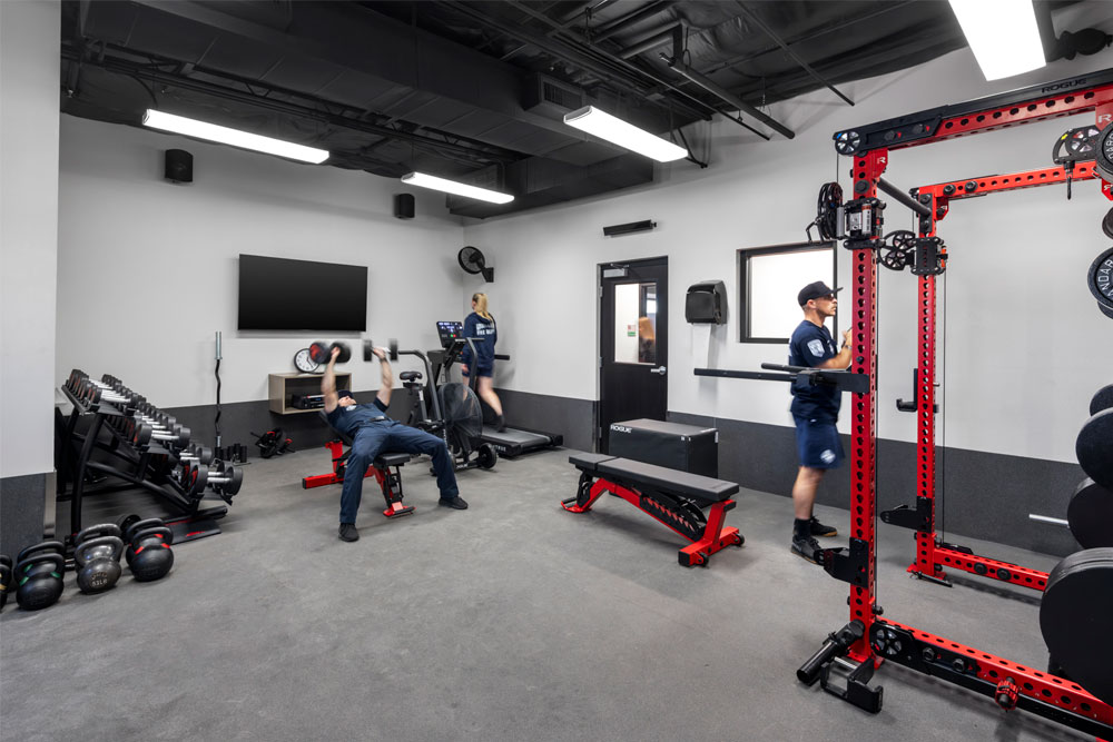 Firefighters working out in fire station gym